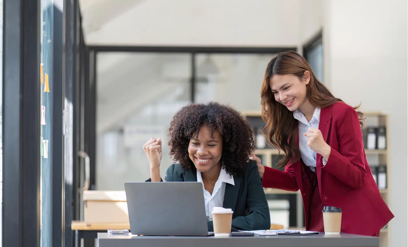 Deux femmes regardent un ordinateur afin de décider si elles préfèrent choisir un expert-comptable en ligne ou de proximité